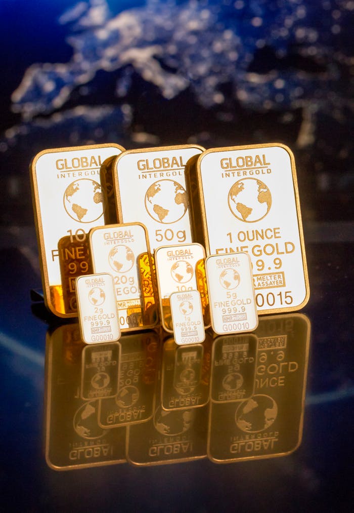services-01 Collection of gold bars featuring a global map and weight inscriptions.